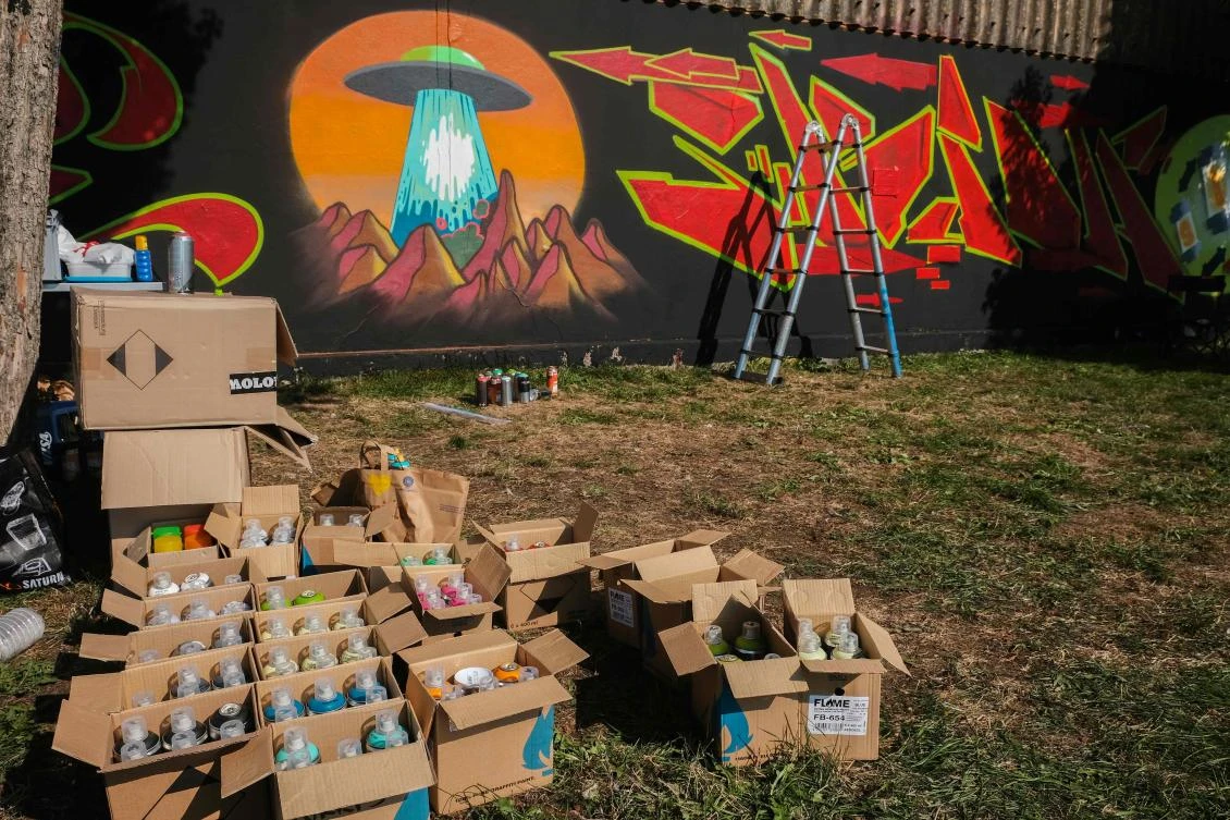 Artists spray Graffiti on a wall in the harbor in Bremerhaven, northern Germany, on August 24, 2019. Every year Graffiti artist can paint a wall on a factory building on a length of 400 meter. / AFP / PATRIK STOLLARZ