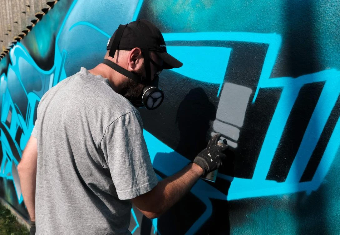Artists spray Graffiti on a wall in the harbor in Bremerhaven, northern Germany, on August 24, 2019. Every year Graffiti artist can paint a wall on a factory building on a length of 400 meter. / AFP / PATRIK STOLLARZ