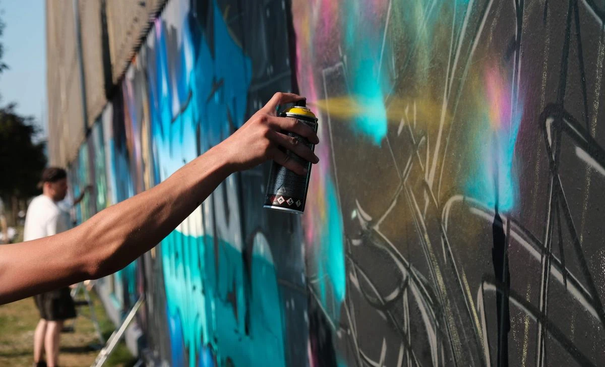 Artists spray Graffiti on a wall in the harbor in Bremerhaven, northern Germany, on August 24, 2019. Every year Graffiti artist can paint a wall on a factory building on a length of 400 meter. / AFP / PATRIK STOLLARZ