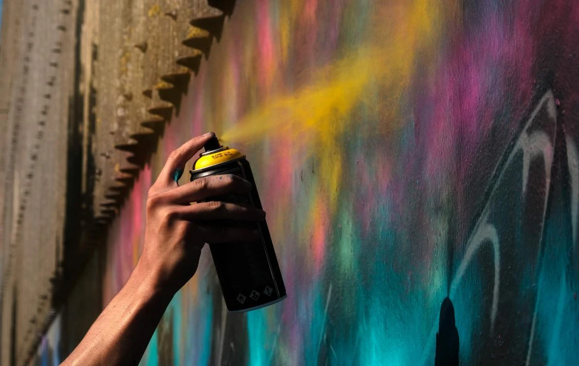 Artists spray Graffiti on a wall in the harbor in Bremerhaven, northern Germany, on August 24, 2019. Every year Graffiti artist can paint a wall on a factory building on a length of 400 meter. / AFP / PATRIK STOLLARZ