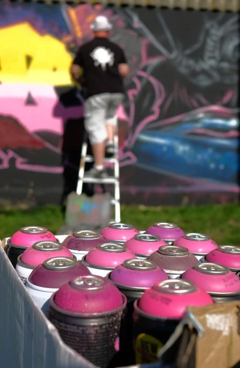 Artists spray Graffiti on a wall in the harbor in Bremerhaven, northern Germany, on August 24, 2019. Every year Graffiti artist can paint a wall on a factory building on a length of 400 meter. / AFP / PATRIK STOLLARZ