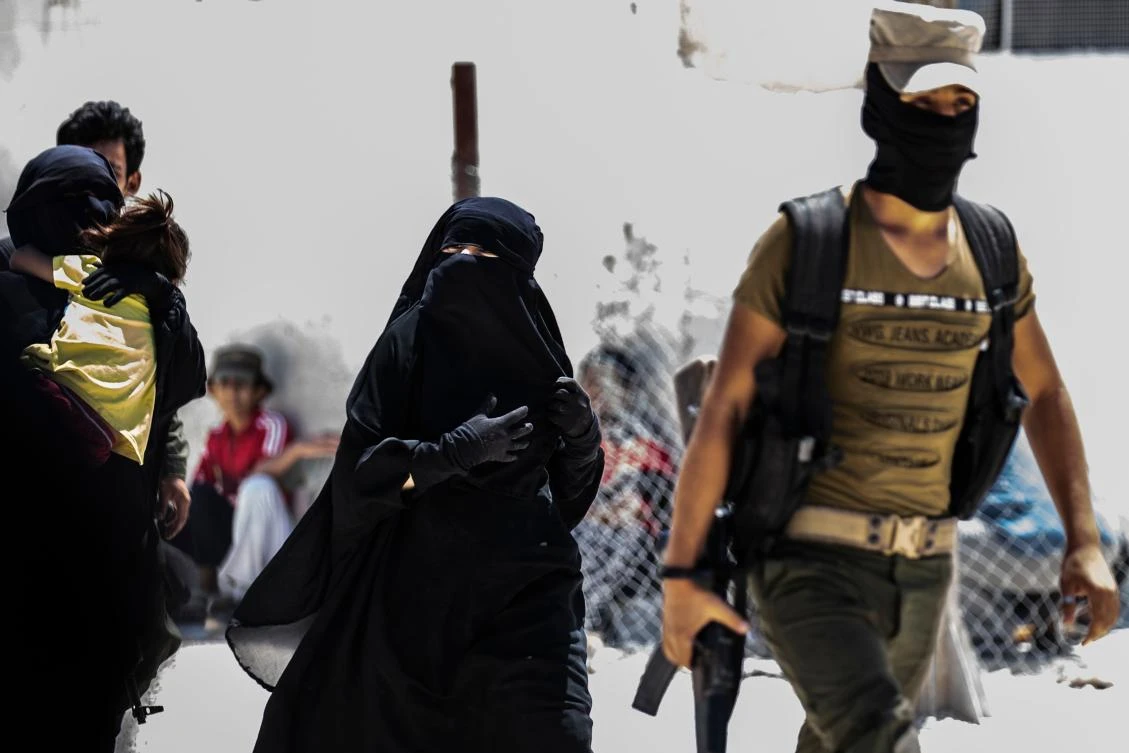 An internal security patrol escorts women, reportedly wives of Daesh group fighters, in the Al-Hol camp in Al-Hasakeh governorate in northeastern Syria, on July 23, 2019. (File/AFP)