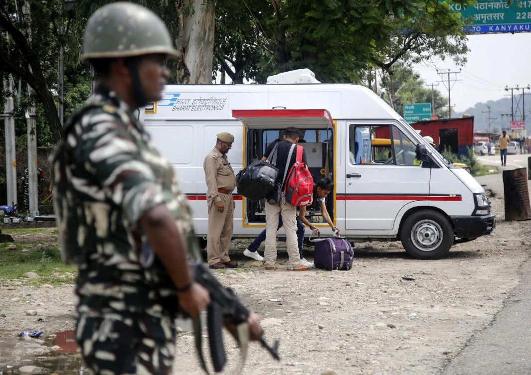 A member of the Indian security forces stands guard as Jammu Kashmir police check the luggage and vehicles of commuters on the Jammu-Srinagar National highway at Nagrota. (AFP)