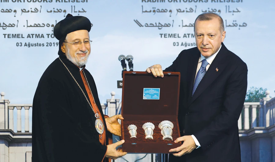 Turkish President Tayyip Erdogan, right, receives a present from Yusuf Cetin, the Turkish Christian relgious leader, in Istanbul on Saturday. (Reuters)