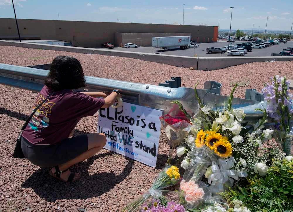 A woman places a Stay Strong sign beside a makeshift memorial outside the Cielo Vista Mall Walmart where a shooting left 20 people dead in El Paso, Texas, on August 4, 2019. (AFP)