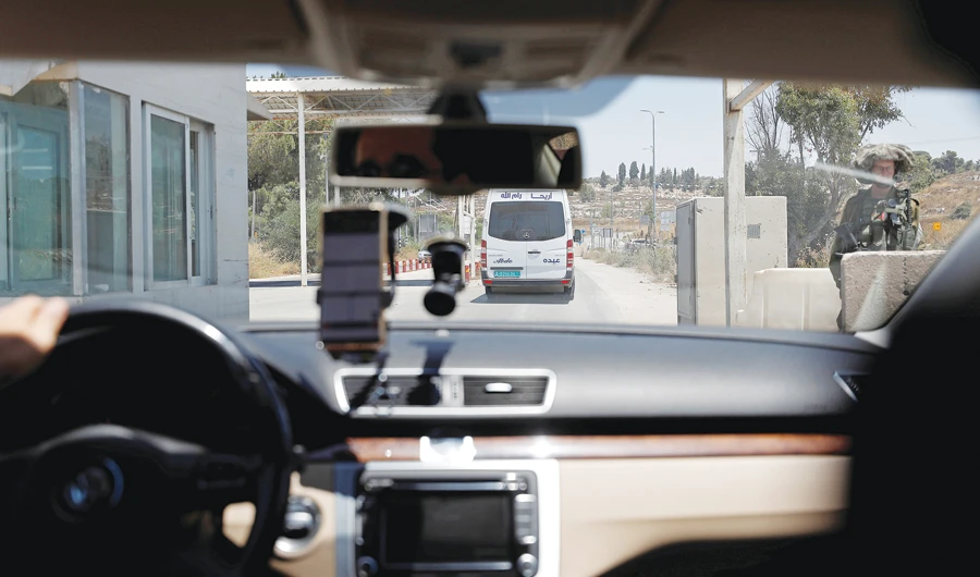 Mohammad Abdel Haleem, CEO of Doroob Technologies, uses Doroob Navigator application as he drives his car at an Israeli checkpoint in Ramallah. (Reuters)