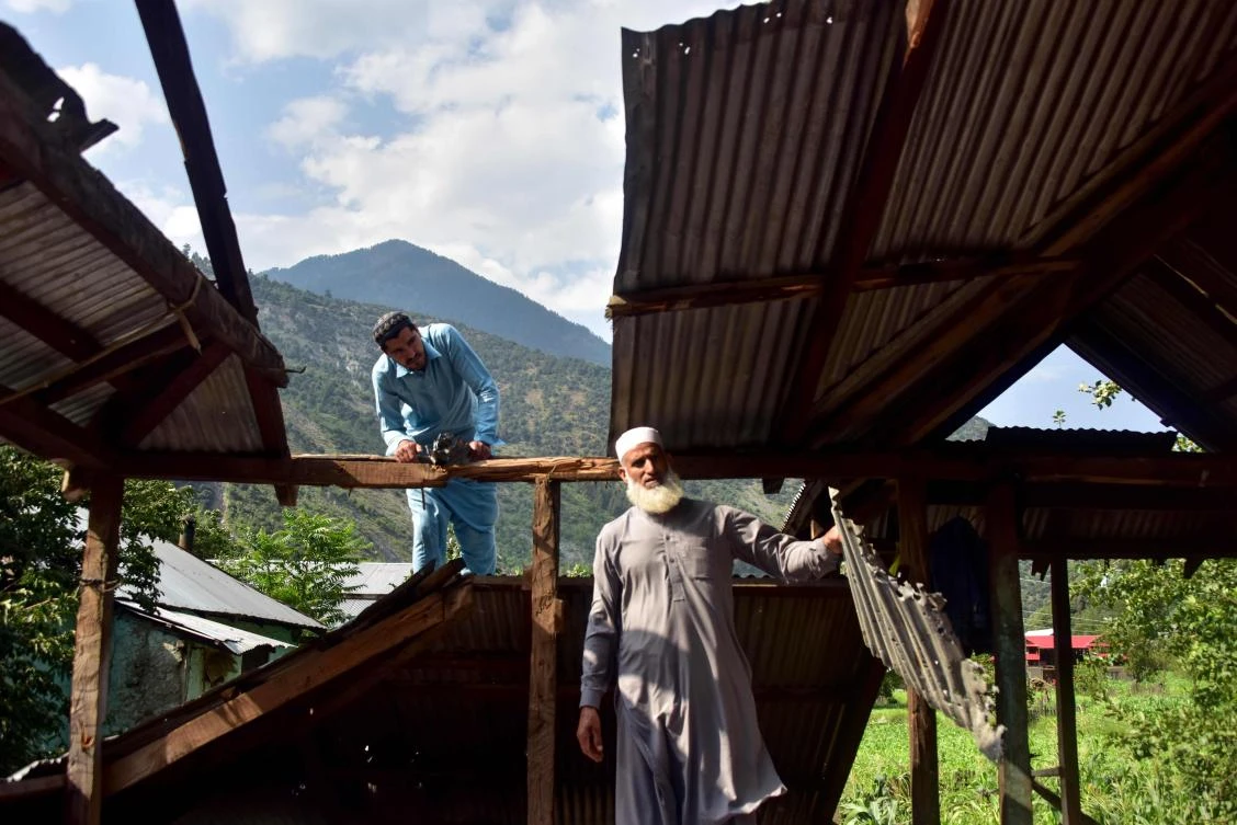 Kashmiri men look at a damaged part of their house following recently cross border shelling at the Line of Control, the de facto border between Pakistan and India, in Neelum Valley of Pakistan-administered Kashmir on August 6, 2019. (AFP)