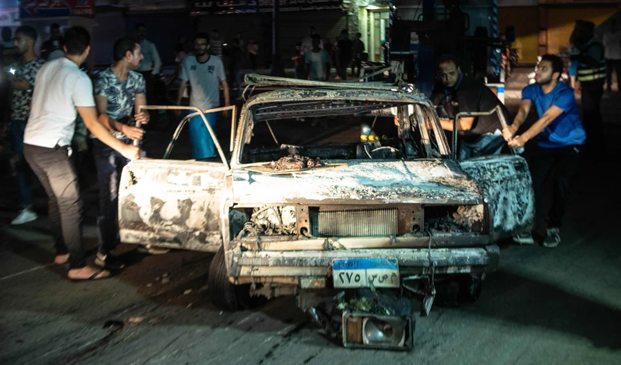 Egyptians surround a burned car after the explosion in Cairo. (AFP)