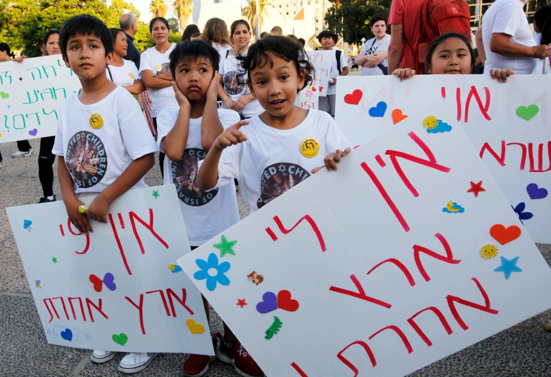 Filipino children carry a banner which reads in Hebrew "We don't have another country" during a protest against deportation in Tel Aviv on August 6, 2019. (AFP / Gil COHEN-MAGEN)