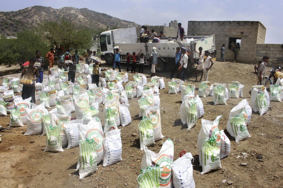 Men deliver aid donations from donors, in Aslam, Hajjah, Yemen. (File/AP)