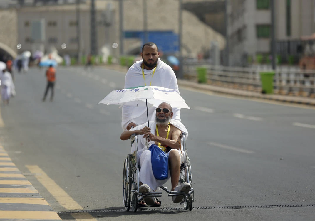 An Egyptian pilgrim pushes his elderly father in a wheelchair Friday at the huge tent city of Mina, in Makkah, Saudi Arabia, where pilgrims will spend the night before heading to Mount Arafat on Saturday. (AP Photo)