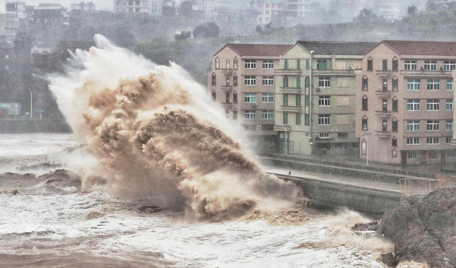 Waves hit a sea wall in front of buildings in Taizhou, China's eastern Zhejiang province on August 9, 2019. (AFP)