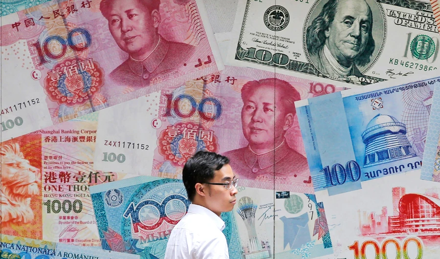 In this June 10, 2019, file photo, a man walks past a money exchange shop decorated with different banknotes at Central, a business district of Hong Kong. (AP)