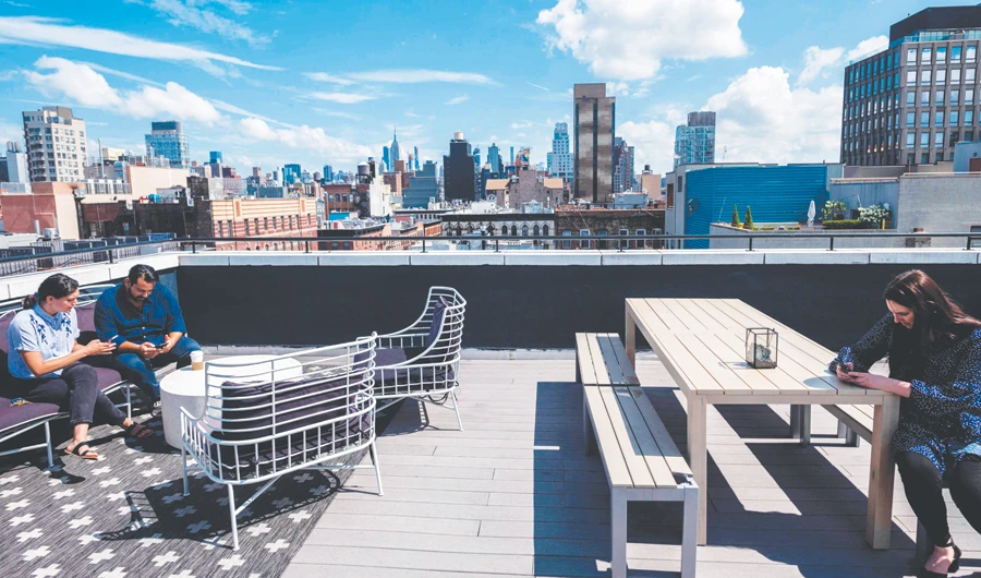 Gil Hirak, head of US operations and community of Quarters, speaks with a colleague on the rooftop of Quarters Co-Living in New York City. (AFP)