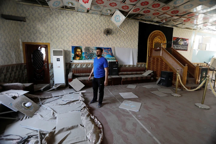A man inspects the damage at a mosque near a weapons depot of an Iraqi militia group after a fire broke out in the depot in Baghdad on August 13, 2019. (REUTERS/Khalid al-Mousily)