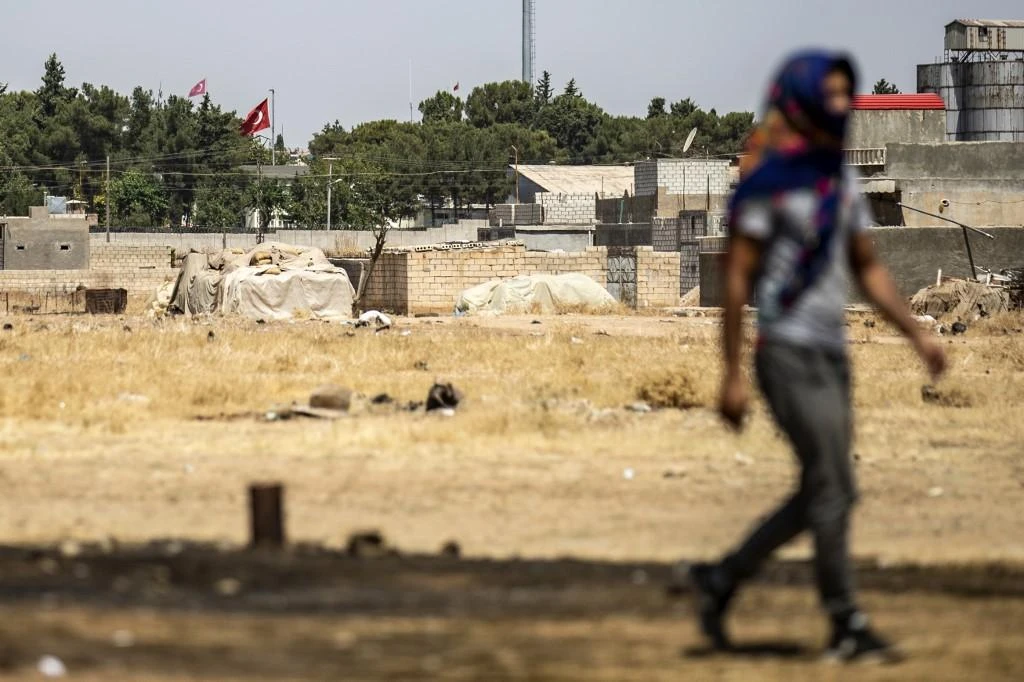 Above, a resident walks in Ras Al-Ain in Syria’s Hasakeh province near the Turkish border. (AFP)