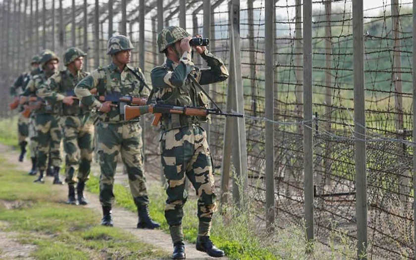 India’s Border Security Force (BSF) soldiers patrol along the fenced border with Pakistan in Ranbir Singh Pura sector near Jammu, Kashmir. (Reuters)