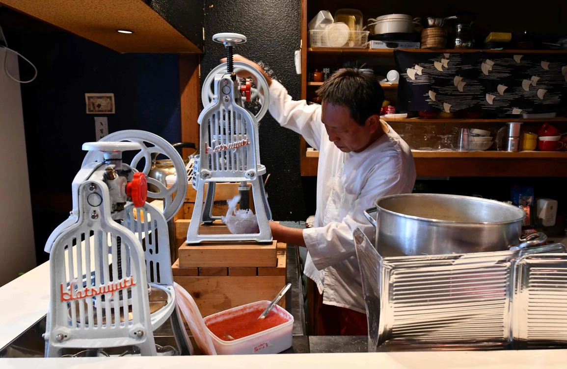 Shop owner Koji Morinishi makes a kakigori dessert with natural ice in the Yanaka district of Tokyo. (AFP)
