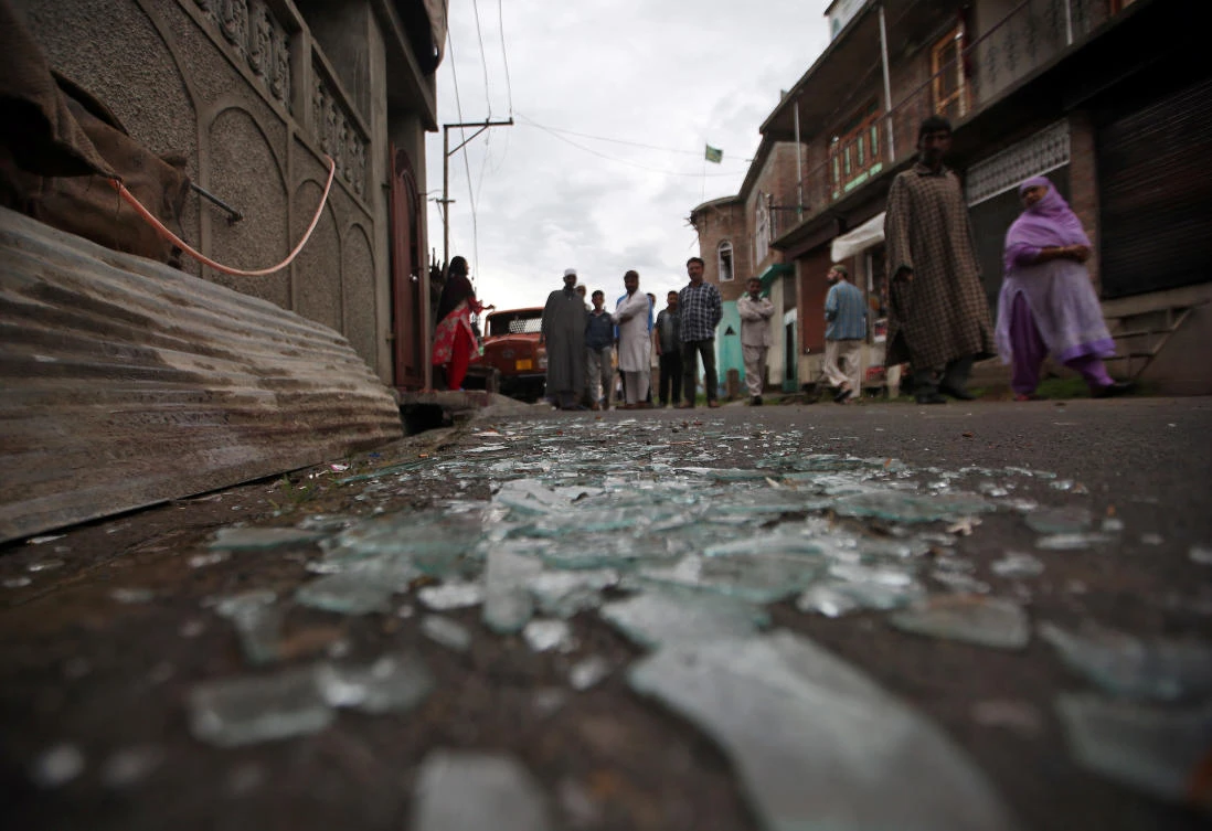 Residents walk past broken window glass after violent clashes between protesters and Indian security forces in Srinagar. (Reuters)
