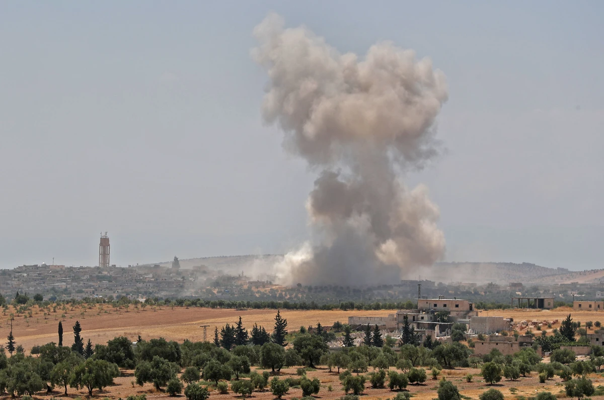 Smoke billows above buildings during a reported air strike by pro-regime forces near the town of Hish in Syria's Idlib province on August 19, 2019. A Turkish military convoy crossed into northwest Syria on Monday. (AFP)