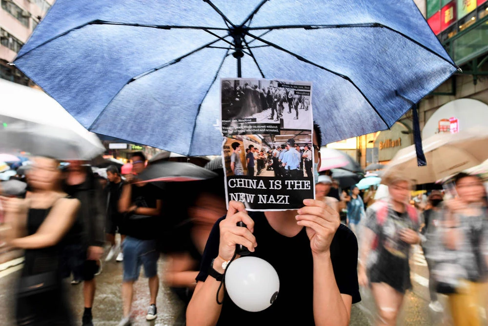 Protesters walk along a street during a rally in Hong Kong on August 18, 2019, in the latest opposition to a planned extradition law that has since morphed into a wider call for democratic rights in the semi-autonomous city. (AFP / Manan Vatsyayana)