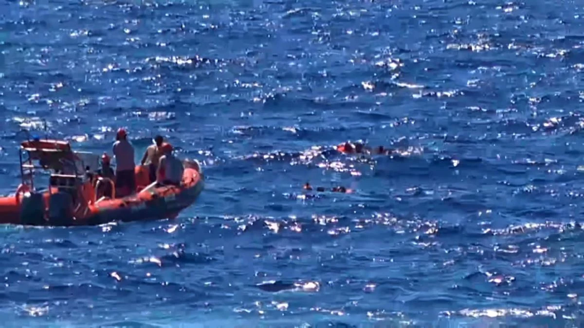 This grab from a video taken by Local Team shows migrants rescued for days by NGO Proactiva Open Arms charity ship, being rescued by a Spanish patrol boat after throwing themselves in the water to try and swim to the nearby Italian island of Lampedusa in a desperate move after days stuck on board, on August 20, 2019. (AFP)