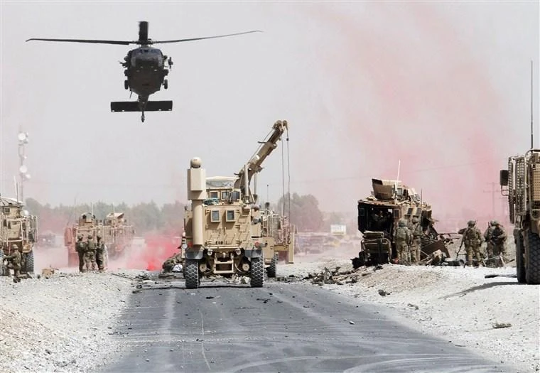 Two US service members have been killed in Afghanistan. Above, US troops assess the damage to a NATO-led military coalition armored vehicle after an attack in Kandahar province. (Reuters)