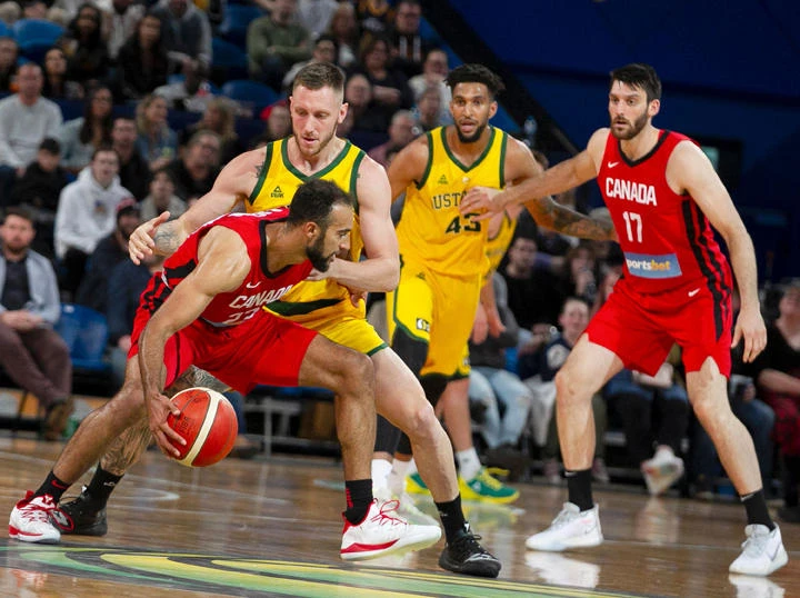 Canada's Phil Scrubb (front) dribbles past Australia's Mitch Creek (L) during the a pre-World Cup friendly basketball match between Australia and Canada in Perth on August 17, 2019. (AFP / TONY ASHBY)