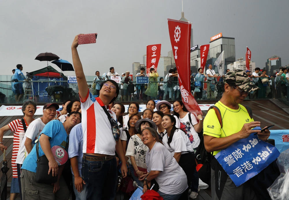 In this July 20, 2019, file photo, pro-China supporters pose for a picture during a counter-rally in support of the police in Hong Kong. Twitter said Monday it has suspended more than 200,000 accounts it believes were linked to the Chinese government and a disinformation campaign targeting the protests in Hong Kong. (AP Photo/Vincent Yu, File)