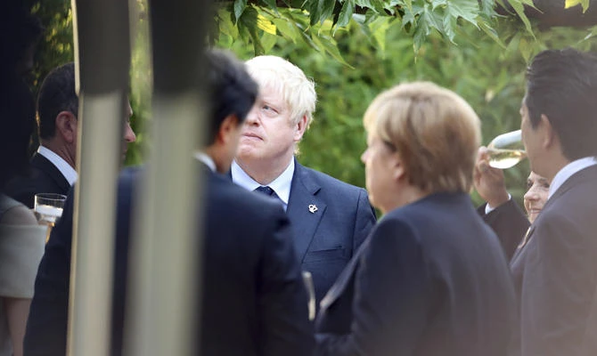 Britain's Prime Minister Boris Johnson, center, attends a working dinner at the Biarritz lighthouse, southwestern France, Saturday, Aug.24, 2019. (AP Photo/Markus Schreiber)