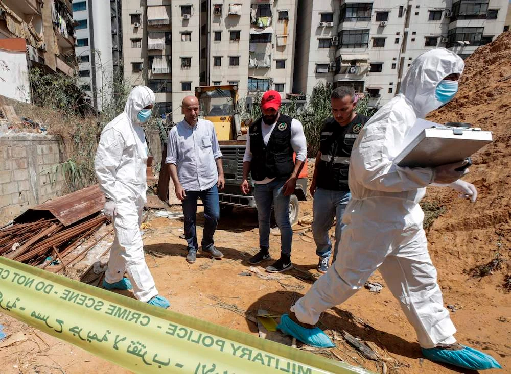 Forensic investigators of Lebanon’s military intelligence inspect the scene where two drones came down in the vicinity of a media center of the Hezbollah movement. (AFP)