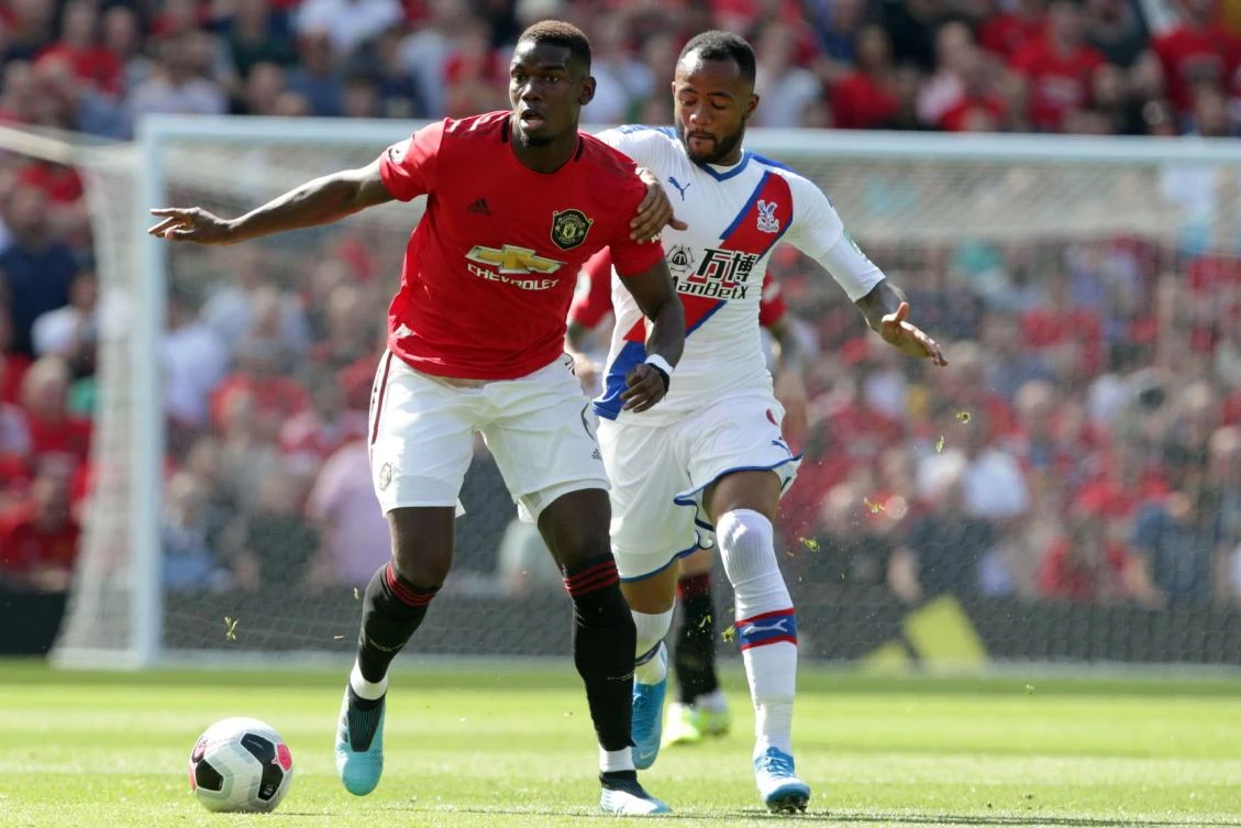 Manchester United's French midfielder Paul Pogba (L) vies with Crystal Palace's French-born Ghanaian striker Jordan Ayew (R) during the English Premier League football match between Manchester United and Crystal Palace at Old Trafford in Manchester, north west England, on August 24, 2019. (AFP)
