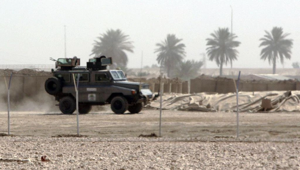 An armoured vehicle belonging to an unidentified private security company escorts a truck (unseen) near Iskandaria, south of Baghdad, Iraq, September 20, 2007 (AFP)