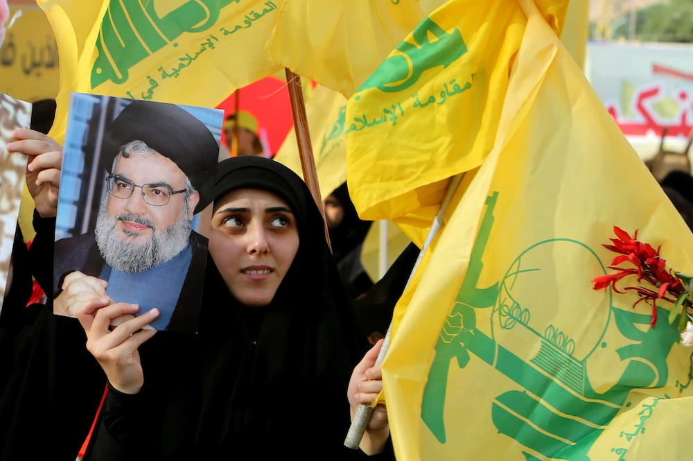 The US on Thursday sanctioned Lebanon-based Jammal Trust Bank SAL and its subsidiaries for allegedly facilitating the financial activities of Hezbollah. One of the group's supporters holds up an image of its leader Sayyed Hassan Nasrallah. (Reuters)