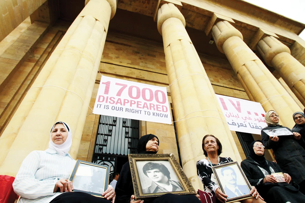 Lebanese women hold the images of missing loved ones at a rally in Beirut in 2012. (AFP)