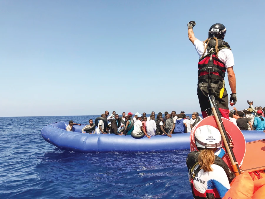 A crew member of the ‘Ocean Viking’ rescue ship stands ready to carry an operation to rescue migrants from an inflatable dinghy in the Mediterranean Sea. (AFP)