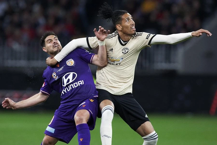 Manchester United’s Chris Smalling (R) fights for the ball with Perth Glory’s Bruno Fornaroli (L) during their pre-season friendly match at Optus Stadium in Perth on July 13, 2019. (Tony Ashby/AFP)