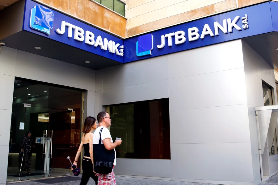 People walk past a branch of Jammal Trust Bank in Beirut, Lebanon, Friday, Aug. 30, 2019. (AP)