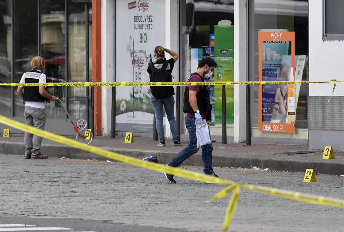 Police officers look for evidence in front of a pharmacy in Villeurbanne on the outskirts of Lyon, south-eastern France on August 31, 2019, after a knife attack which has left one dead and nine injured. (AFP)