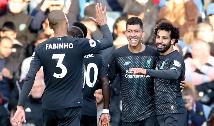 Liverpool players celebrate their third goal during their match against Burnley on Saturday. (Reuters)