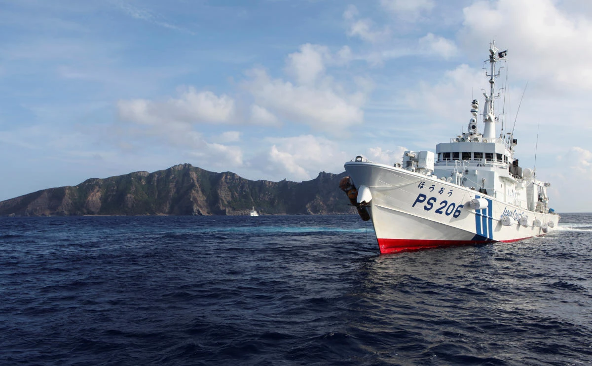 A Japan Coast Guard vessel sails in front of one of the disputed islands in the East China Sea. (Reuters)