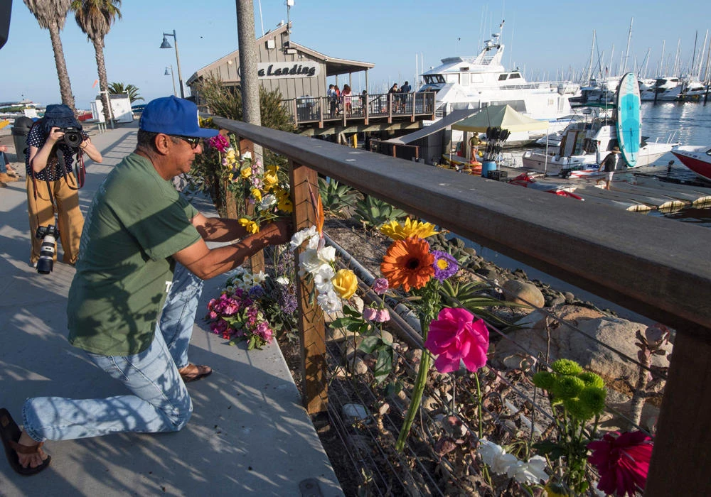 A man places flowers at a memorial wall near the Truth Aquatics moorings, where the Conception, which burned and sank off the Santa Cruz Islands, was based in Santa Barbara, California. (AFP)