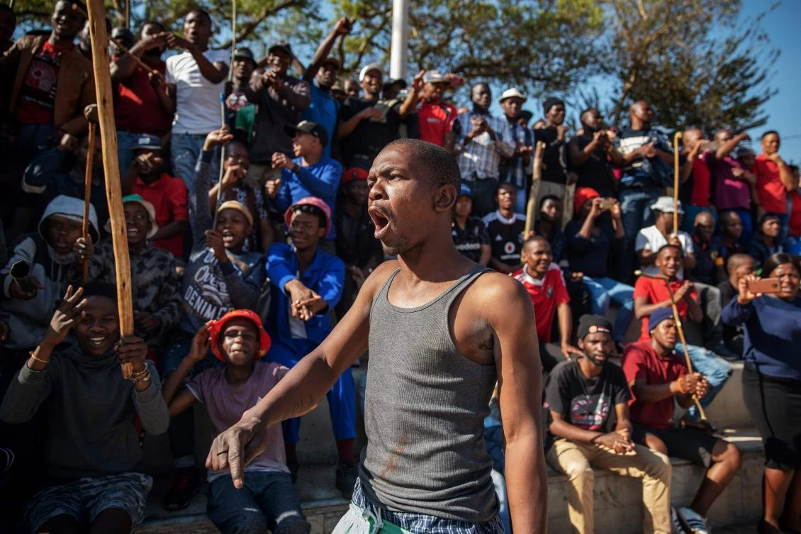 A Zulu resident of the Jeppe Men’s Hostel shouts encouragement while others brandish knobkerries in the Johannesburg CBD, after South Africa’s financial capital was hit by a new wave of anti-foreigner violence. (AFP)