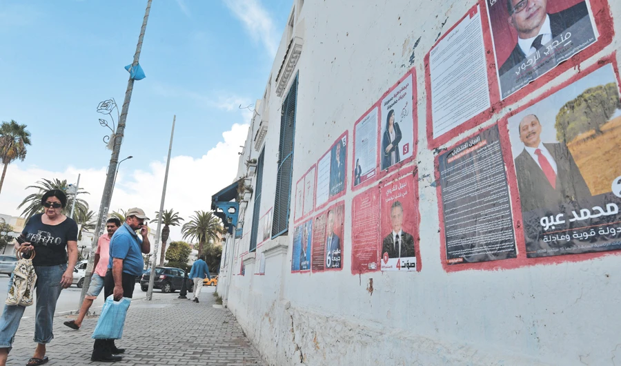 A man looks at posters of Tunisian presidential candidates in the capital Tunis. (AFP)