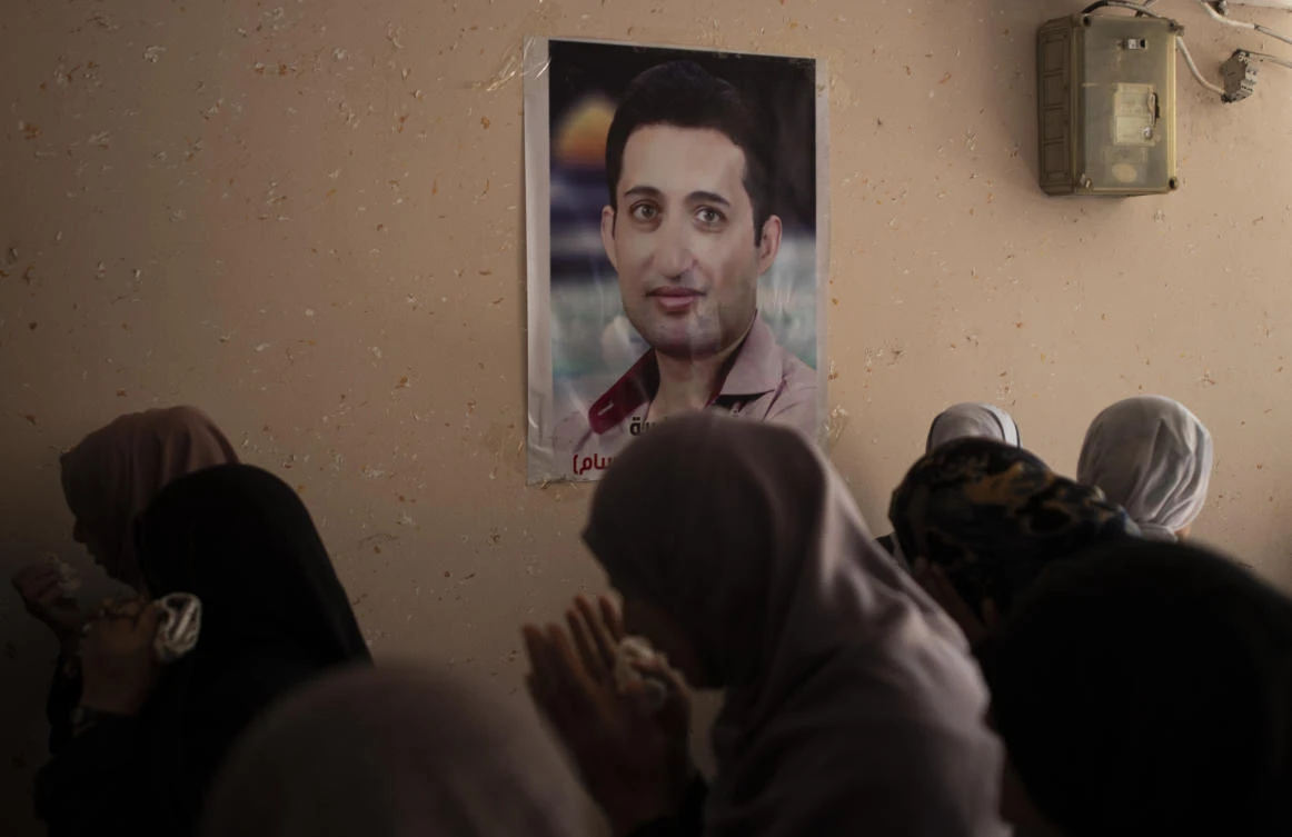In this Sunday, Aug. 25, 2019, photo, relatives of Palestinian activist Tamer Sultan, 38 years old, mourn next to a picture of him on a wall in his family home during his funeral in the town of Beit Lahiya, northern Gaza Strip. (AP)