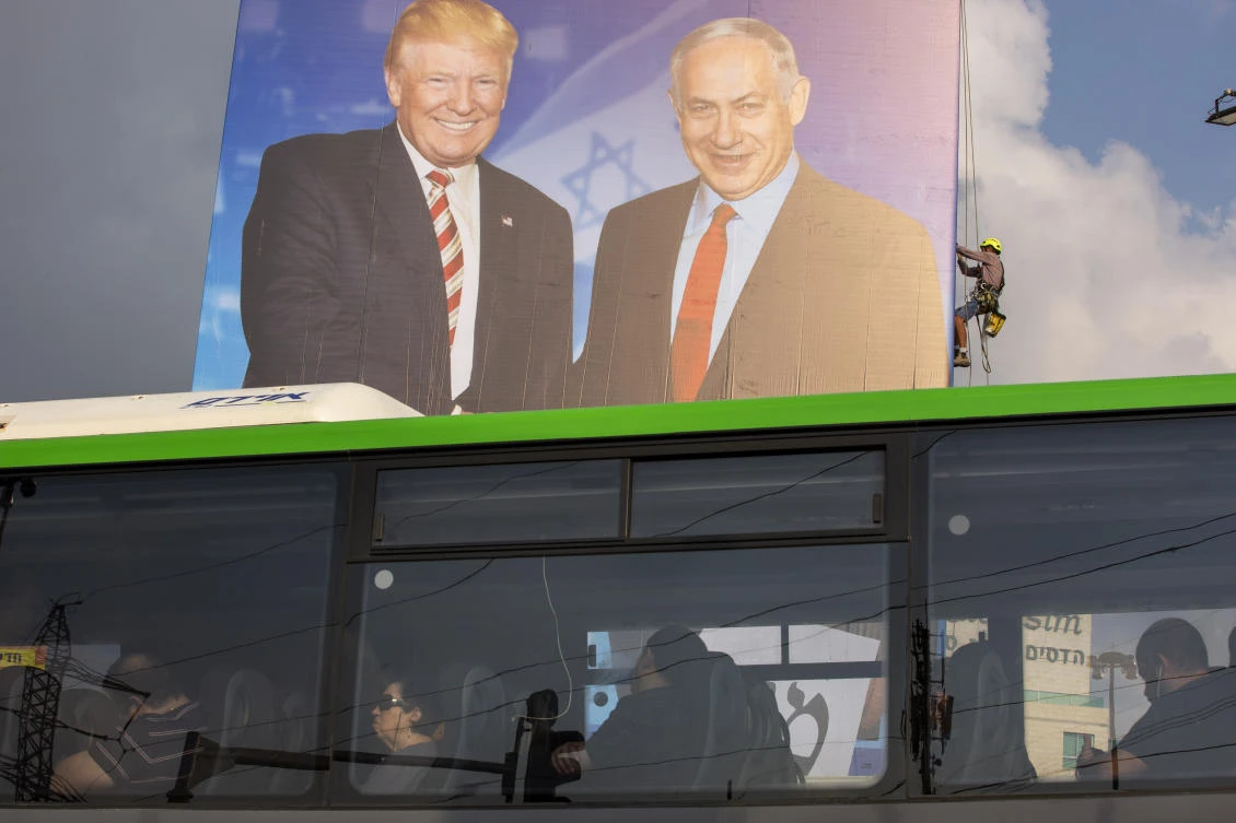 A worker hangs an election campaign billboard of the Likud party shows Israeli Prime Minister Benjamin Netanyahu, right, and US President Donald Trump in Bnei Brak, Israel, Sunday, Sept 8, 2019. (AP)