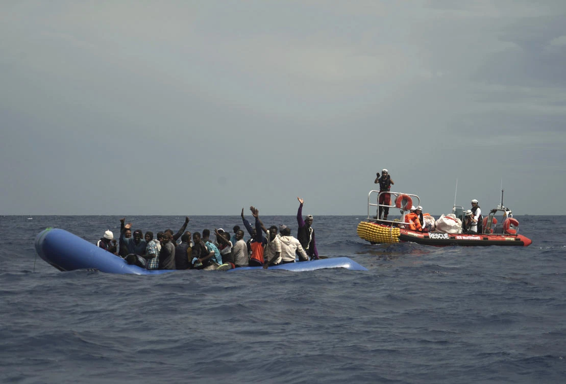 Migrants are seen waving after being found some 14 nautical miles from the coast of Libya in Mediterranean Sea, Sunday, Sept. 8, 2019. (AP)