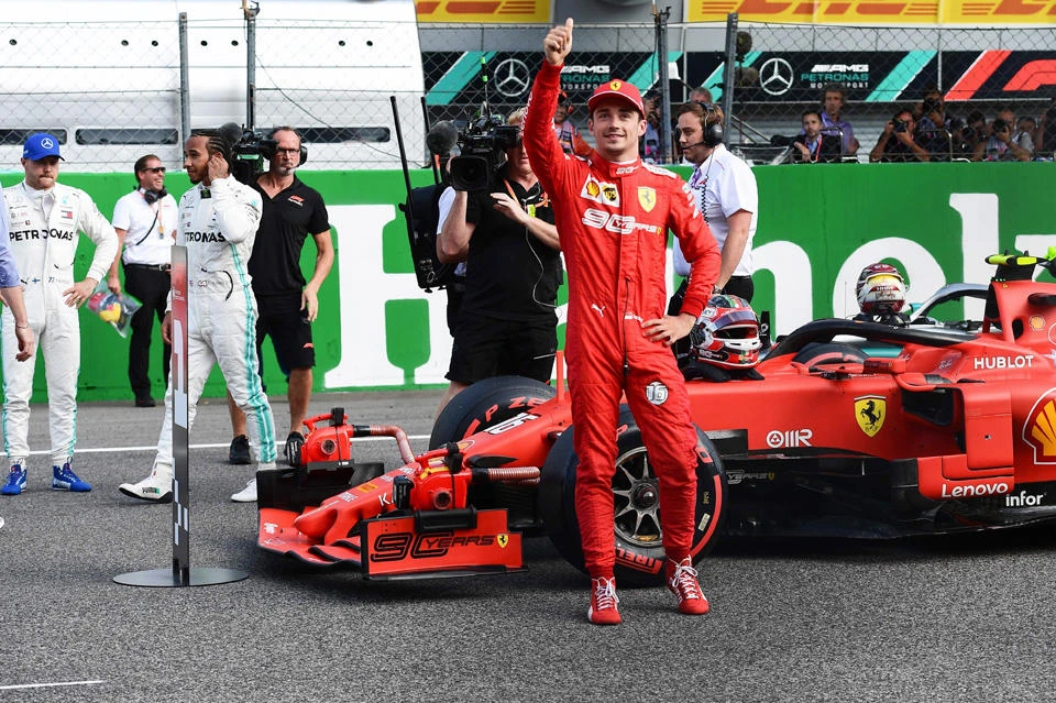 Ferrari's Monegasque driver Charles Leclerc (R) celebrates winning the pole position after the qualifying session at the Autodromo Nazionale circuit in Monza on September 7, 2019 ahead of the Italian Formula One Grand Prix. (AFP / Miguel Medina)