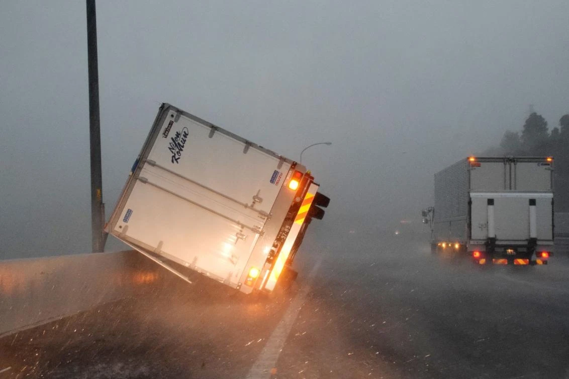 A truck turned over by high winds lies on a highway in Narita, Chiba prefecture on September 9, 2019. A powerful typhoon with potentially record winds and rain battered the Tokyo region on September 9, sparking evacuation warnings to tens of thousands, widespread blackouts and transport disruption. - Japan OUT / AFP / JIJI PRESS / STR