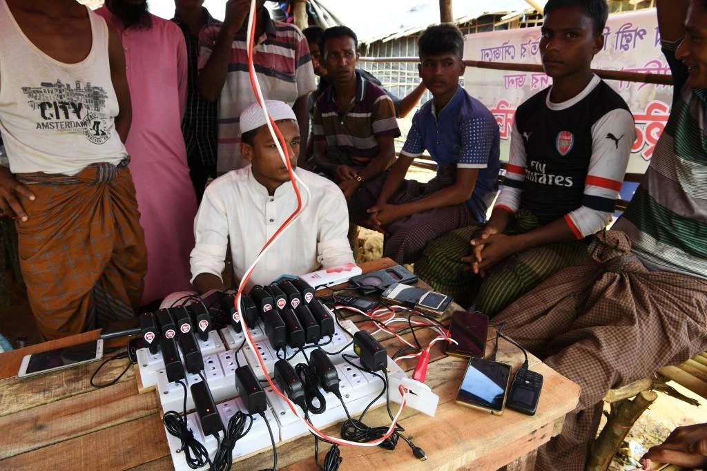 Rohingya refugees wait to get their mobile phones charged at Bangladesh’s Kutupalong refugee camp, where mobile phone retailers have been told not to sell any new SIM cards, in this October 7, 2017. (AFP)